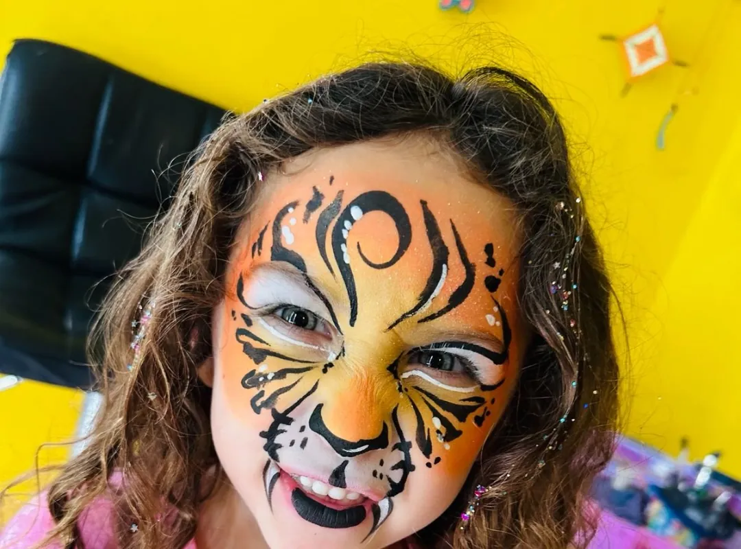 Nena con maquillaje artístico de tigre en la cara