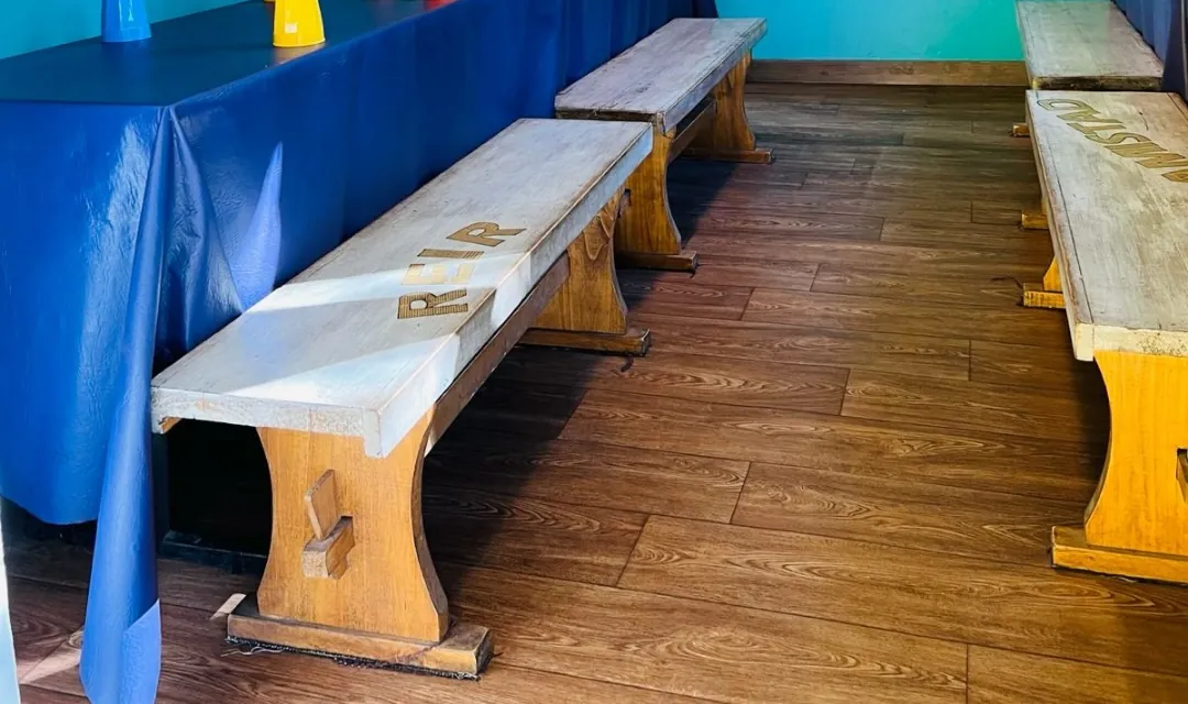 Mesas largas y bancos de madera en el comedor para niños