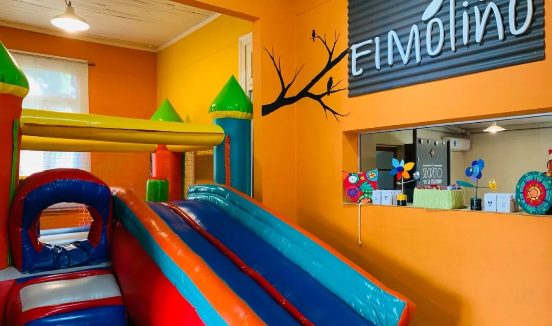 Sector interno con paredes naranjas, inflable con tobogán y el logo de El Molino