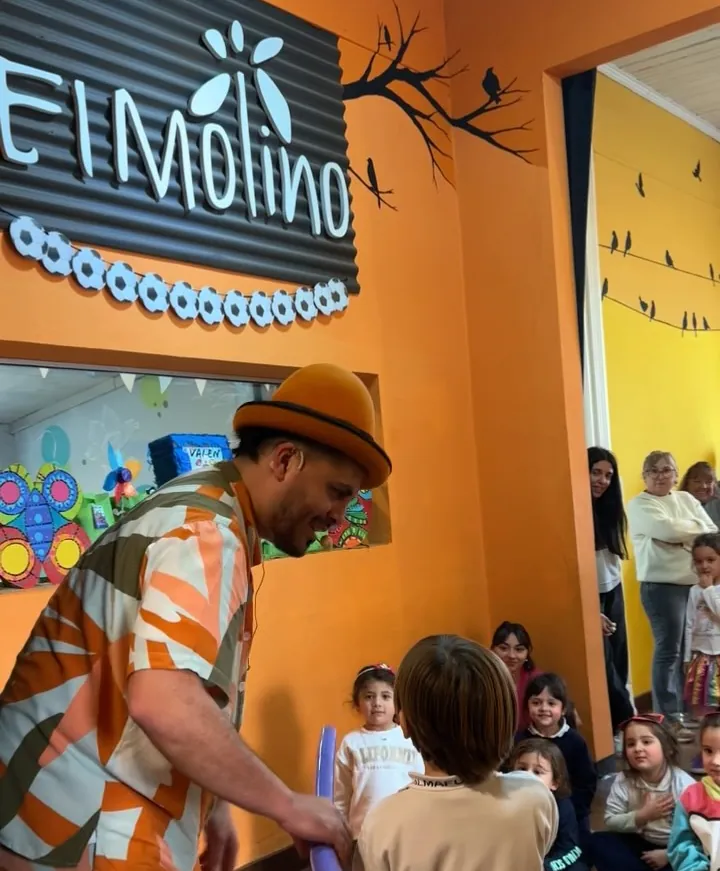 Animador armando figuras con globos para los chicos en el salón naranja